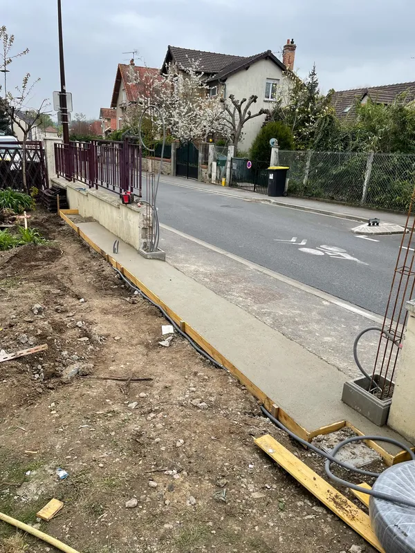 Mur de soutènement maçonné le long d'une rue en pente du 91